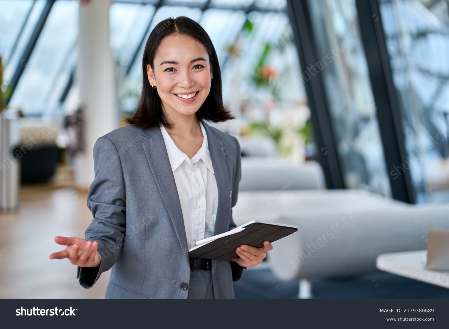stock-photo-happy-young-asian-saleswoman-looking-at-camera-welcoming-client-smiling-woman-executive-manager-2179380689