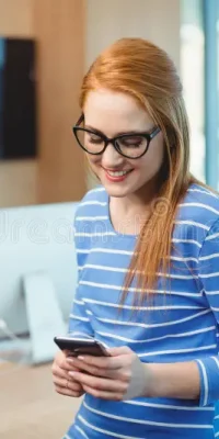female-executive-using-mobile-phone-office-smiling-385017087