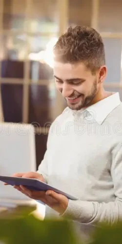 happy-businessman-using-digital-pc-colleagues-working-background-creative-office-385044394